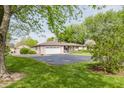 Lovely ranch-style home with brick exterior, spacious driveway, and mature trees in the yard at 807 Whitmore St, Anderson, IN 46012