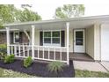 Welcoming front porch with fresh mulch landscaping, painted railing, and decorative shutters offers curb appeal at 8145 Railroad Rd, Indianapolis, IN 46217
