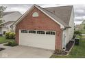 Attached two-car garage with brick and vinyl siding, complementing the home's exterior at 820 Scotch Pine Dr, Greenwood, IN 46143