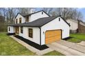 Side exterior view of a two-story home, highlighting a modern garage door at 8315 N Payne Rd, Indianapolis, IN 46268