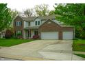 Charming two-story home featuring a well-manicured lawn, brick accents, and an attached two-car garage at 8727 Redditch Dr, Avon, IN 46123