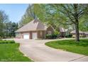 Spacious home boasts an attached garage, beautiful landscaping, and a curved driveway at 923 Woodcrest Way, Anderson, IN 46012