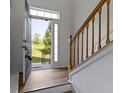 Inviting foyer features hardwood floors, a staircase with wooden banister, and views of the outdoors at 9417 Glencroft Way, Indianapolis, IN 46250