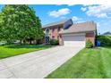 Traditional brick home with an attached two car garage and a large driveway at 10746 Gateway Dr, Fishers, IN 46037