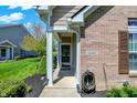 Inviting entryway with a glass storm door, brick facade, and trimmed greenery for curb appeal at 10992 Chapel Woods S Blvd, Noblesville, IN 46060
