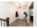 Inviting entryway featuring wood floors, a modern light fixture, and ample natural light at 13323 Susser Way, Fishers, IN 46037