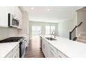 Open kitchen with quartz countertops, stainless appliances, and view to living area at 13776 Tender Dr, Carmel, IN 46032