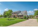 Spacious brick home with a large front yard and a long driveway leading to the property at 14162 Nicholas Dr, Carmel, IN 46074