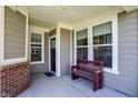 Inviting front porch featuring a wooden bench, neutral tones, and ample natural light from nearby windows at 15004 Stonneger St, Westfield, IN 46074