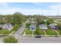 Aerial view showcasing the blue house within a quiet neighborhood, surrounded by mature trees and lush greenery at 2263 N Rural St, Indianapolis, IN 46218