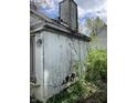 Close-up reveals extensive damage to the back of the house and overgrown foliage at 2517 Baur Dr, Indianapolis, IN 46220