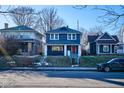 Street view of a two-story home featuring blue siding, a bright red door, and a welcoming front porch at 2714 N Capitol Ave, Indianapolis, IN 46208
