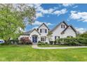 Beautiful two-story white brick home with a well-manicured lawn and a blue front door at 2979 Kings Ct, Carmel, IN 46032
