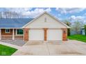 Spacious two-car garage with brick accents and concrete driveway at 310 Edgewood E Pl, Anderson, IN 46011