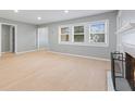 Bright living room with light wood floors, large windows, neutral walls, and a modern fireplace at 3421 Arthington Blvd, Indianapolis, IN 46218