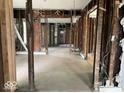 A vacant living room space reveals its framing and rough hardwood floors, hinting at the potential for custom renovation at 438 N Keystone Ave, Indianapolis, IN 46201