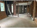 A vacant living room space reveals its framing and rough hardwood floors, hinting at the potential for custom renovation at 438 N Keystone Ave, Indianapolis, IN 46201