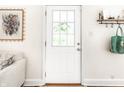 Bright interior shot with a view of the front door from the living room, decorated with a painting at 4406 Carrollton Ave, Indianapolis, IN 46205