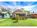 Inviting home with a screened porch, quaint landscaping, and a vibrant green lawn under a bright sky at 4623 Evanston Ave, Indianapolis, IN 46205