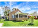 Exterior view with a charming screened-in front porch and verdant lawn, showcasing curb appeal at 4623 Evanston Ave, Indianapolis, IN 46205