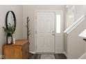 Bright foyer showcasing the front door with sidelight, wood-look floors, a mirror and coat rack at 4625 Elkhorn Ct, Noblesville, IN 46062