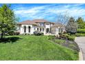 A light-colored two-story home surrounded by a lush green lawn, showcasing classic architecture and landscaping at 4726 Ellery Ln, Indianapolis, IN 46250