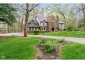 Well-maintained brick and Tudor home with a circular driveway and manicured landscaping at 5001 Woodrose Ln, Anderson, IN 46011