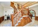 Grand foyer featuring a wooden staircase, tile flooring, and arched doorways at 5001 Woodrose Ln, Anderson, IN 46011