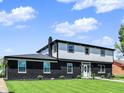 Charming two-story home featuring a striking black brick facade, well-manicured lawn, and a bright white front door at 5354 Brendon Park Dr, Indianapolis, IN 46226