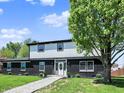 Charming two-story home boasts a striking black brick facade and a welcoming front yard with mature trees at 5354 Brendon Park Dr, Indianapolis, IN 46226