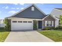 Well-maintained home with blue siding, brick accents, green lawn, and an attached two-car garage at 5465 Tanglewood Ln, Whitestown, IN 46075