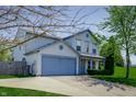 Attractive two-story home boasts a two-car garage and well manicured shrubbery at 6209 Amber Valley Ln, Indianapolis, IN 46237