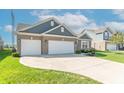 Beautiful home with a manicured lawn, attached garage, and a long concrete driveway at 6229 Farlin Dr, Whitestown, IN 46075
