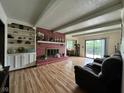 Open concept living room with a brick fireplace, built-in shelving, and access to the backyard at 645 Boulder Rd, Indianapolis, IN 46217