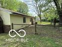 The backyard features a wood fence and mature trees, offering a private outdoor space at 7916 Catawba Ct, Indianapolis, IN 46217