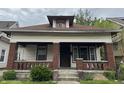 A charming, craftsman-style home featuring a cozy front porch with brick columns and steps at 811 N Oxford St, Indianapolis, IN 46201
