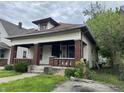 A charming, craftsman-style home featuring a cozy front porch with brick columns and steps at 811 N Oxford St, Indianapolis, IN 46201