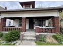 A charming, craftsman-style home featuring a cozy front porch with brick columns and steps at 811 N Oxford St, Indianapolis, IN 46201