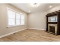 Sunlit living room with a decorative fireplace, light wood flooring and ample natural light from the large windows at 1330 Marlowe Ave, Indianapolis, IN 46202