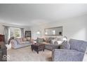 Comfortable living room featuring neutral tones, plush seating, and large windows at 13363 Lantern Rd, Fishers, IN 46038