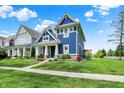 Charming two-story home with a blue exterior, inviting front porch, and well-manicured lawn at 1404 Rosebank Dr, Westfield, IN 46074
