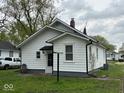 View of the rear of the home showing a small back entry and lush lawn at 1405 S Ribble Ave, Muncie, IN 47302