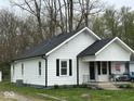 Exterior elevation of the home, showcasing white siding, a new roof, and neat landscaping at 1405 S Ribble Ave, Muncie, IN 47302