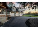 Close up showcasing a three car garage with an asphalt driveway at 15617 Westfield Blvd, Carmel, IN 46033