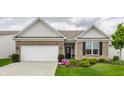 Charming brick home featuring an attached garage, manicured lawn, and a welcoming front entrance at 16044 Loire Valley Dr, Fishers, IN 46037