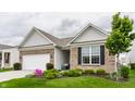 Well-maintained exterior with brick accents, a lush green lawn, and mature tree at 16044 Loire Valley Dr, Fishers, IN 46037