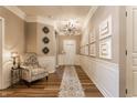 Elegant hallway featuring wood floors, decorative wall accents, and stylish lighting at 16044 Loire Valley Dr, Fishers, IN 46037