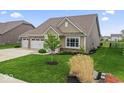Attractive home with an attached three-car garage, a green lawn, and lovely landscaping at 161 Tamarack Larch Blvd, Cicero, IN 46034