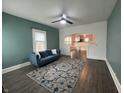 Inviting living room with teal walls, ceiling fan and stylish blue sofa, flows into the adjacent dining area at 1622 S Randolph St, Indianapolis, IN 46203