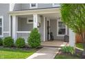 Inviting covered front porch with decorative shrubs and welcoming decor at 1909 Orange St, Indianapolis, IN 46203